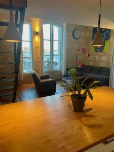a living room with a wooden table with a plant on it at Les Capucins in Bordeaux