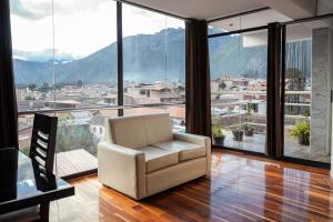 a white chair in a room with a large window at Hotel California Urubamba in Urubamba