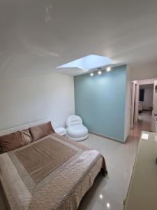 a white bedroom with a bed and a toilet at F2 type apartment Near Stade de France in Saint-Denis