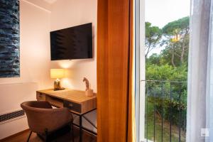 Habitación con escritorio y ventana. en La Casa nel Parco luxury b&b, en San Lazzaro di Savena