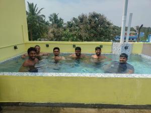un grupo de hombres en una piscina en La nest residency en Pondicherry