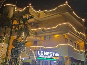 een gebouw met een verlicht bord ervoor bij La nest residency in Pondicherry