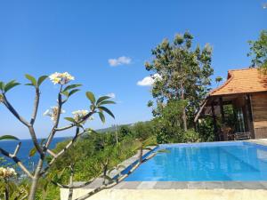 a villa with a swimming pool and a view of the ocean at The Somayan Bungalows in Nusa Penida