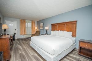 a bedroom with a large white bed and a desk at Tremont Lodge & Resort in Townsend