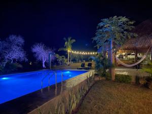 una piscina por la noche con un complejo en Bungalow Gaviota c/vistas increíbles al Océano Pacífico, en Perihuete