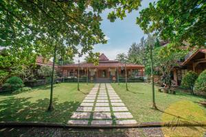 une maison avec une passerelle devant une cour dans l'établissement Joglo Garut Cottage Syariah by My Hospitality, à Bojongsalam