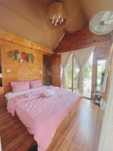 a bedroom with a large bed with pink sheets at Utopia Homestay Đà Lạt in Khu Chi Lăng