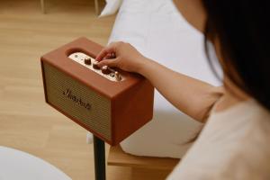 uma mulher está segurando uma caixa marrom em uma cama em The Hyoosik Aank Hotel Ilsan Tanhyeon em Goyang