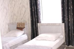2 camas en una habitación con paredes blancas y negras en Гостевой дом Эверест en Arkit