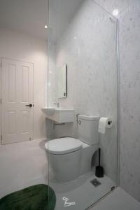 a bathroom with a toilet and a glass shower at Kanchanaburi Modern Home in Kanchanaburi