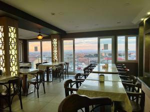 een restaurant met tafels, stoelen en ramen bij Elit Palace Hotel in Istanbul