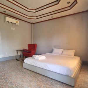 1 dormitorio con 1 cama y 1 silla roja en Lanta msd bungalow en Phra Ae beach