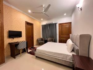 a bedroom with a bed and a flat screen tv at Rhodium Hotel ONE in Islamabad