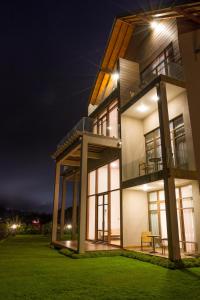 a large house with a lawn in front of it at night at Tea Plant Nuwara Eliya in Nuwara Eliya