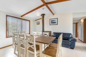 101 Batson Pde - Waterfront - BYO Linen في Hindmarsh Island: غرفة طعام مع طاولة وكراسي وأريكة