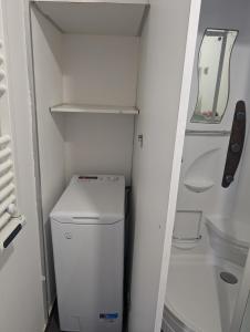 um pequeno frigorífico branco com uma máquina de lavar roupa em Duplex "La belle vue " em Entrevaux