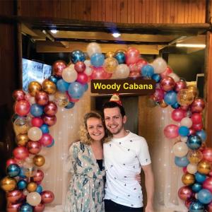 Ein Mann und eine Frau stehen vor einem Ballonbogen. in der Unterkunft Woody Cabana in Trincomalee