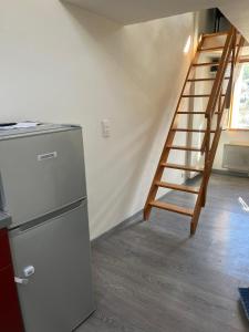 Il comprend une cuisine équipée d'un réfrigérateur et un escalier en bois. dans l'établissement Duplex "La belle vue ", à Entrevaux