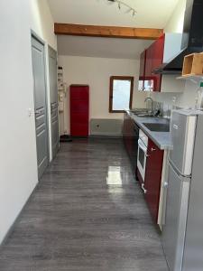 uma cozinha com armários vermelhos e um frigorífico vermelho em Duplex "La belle vue " em Entrevaux