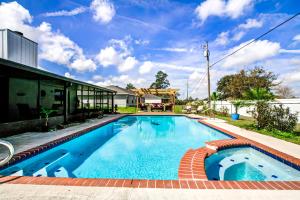 een zwembad met een bakstenen loopbrug rond een huis bij Tranquil Oasis Haven in Marion Oaks
