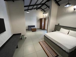 une chambre avec un lit et une chaise dedans dans l'établissement Parnakuti Cottage, à Trimbak