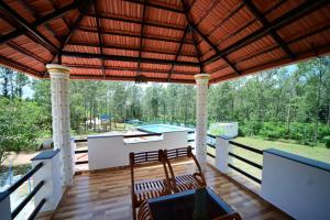 - une terrasse couverte avec un banc et une piscine dans l'établissement SIPAYI RESORT COORG, à Kushalanagar