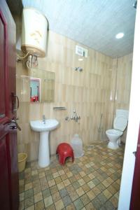 uma casa de banho com um lavatório e um WC em SIPAYI RESORT COORG em Kushālnagar