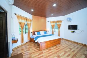 a bedroom with a bed and a flat screen tv at SIPAYI RESORT COORG in Kushālnagar
