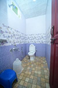 a bathroom with a toilet in a purple room at SIPAYI RESORT COORG in Kushālnagar
