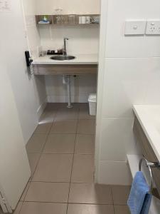 a small bathroom with a sink and a toilet at Aston Motel Yamba in Yamba