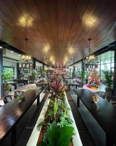 ein Restaurant mit Holztischen, Stühlen und Pflanzen in der Unterkunft The Vineyard at Tanauan in Tanauan