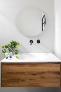 ein Badezimmer mit einem weißen Waschbecken und einem Spiegel in der Unterkunft Spacious & Modern 2BD Apartment 2-min From Beach by Sea N' Rent in Tel Aviv