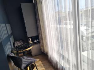 a room with a table and chairs and a large window at Dayssin Boutique hotel in Yerevan