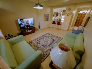 a living room with a couch and a tv at Olive Escapes in Dar es Salaam