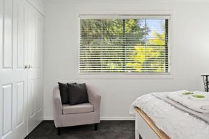 Un dormitorio con una cama y una silla y una ventana. en The Black Door, en Bright