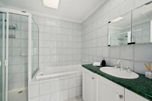 Un baño blanco con bañera y lavabo. en The Black Door, en Bright 11 fotos más