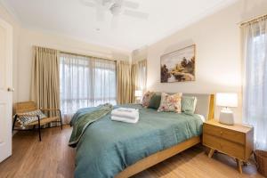 1 dormitorio con 1 cama con colcha verde en The Parkers, en Bright