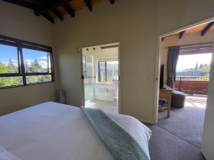Schlafzimmer mit einem Bett und Blick auf ein Bad in der Unterkunft TekapoB2 Lakeview Apartment in Lake Tekapo