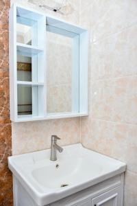a bathroom with a sink and a mirror at Wills House, Three Bedroom with Extra Bed in Kilimani in Nairobi