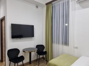 a hotel room with a bed and two chairs and a tv at Day Inn hotel in Yerevan +40 photos