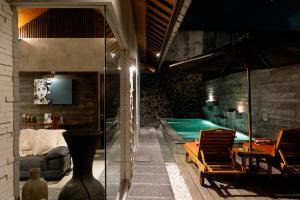 a living room with a swimming pool and a house at Bracha Villas Bali - CHSE Certified in Seminyak