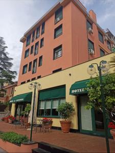 un hotel con mesas y sillas frente a un edificio en Hotel La Capannina, en Génova