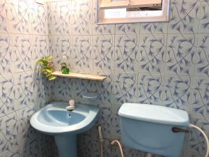 uma casa de banho com um WC azul e um lavatório. em The Drop In Madiha I Double Bedroom with private Bathroom em Madihe East