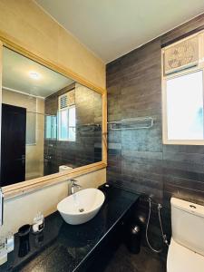 a bathroom with a sink and a mirror and a toilet at The Niche Hikkaduwa - 10 minutes to the beach in Hikkaduwa
