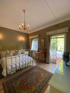 a bedroom with a bed with a chandelier at Garden Court in Potchefstroom +53 photos