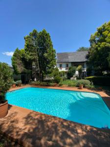 a large blue swimming pool in front of a house at Garden Court in Potchefstroom