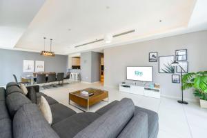ein Wohnzimmer mit einem Sofa und einem TV in der Unterkunft FAM Living - Mada Residences Downtown Dubai in Dubai