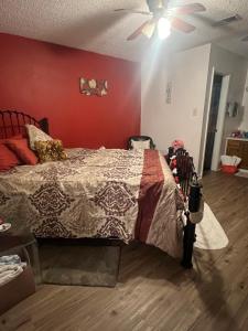 um quarto com uma cama e uma parede vermelha em City Center Home ONeal lane em Baton Rouge