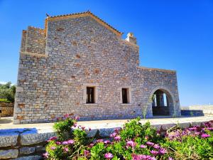 a brick building with flowers in front of it at Athevillas Antonis in Mína +44 photos