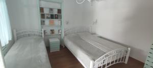 two twin beds in a bedroom with a book shelf at Hovit Holiday Home in Margahovit